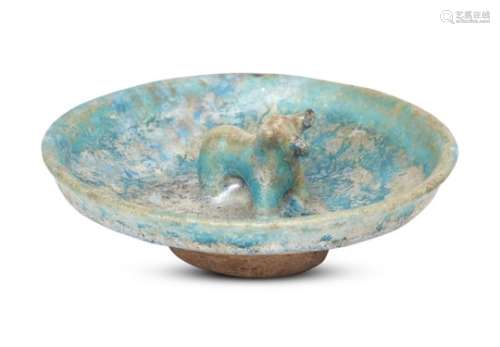 A Kashan turquoise-glazed pottery dish with moulded bull, Iran, 12th century, on a short foot,