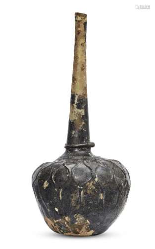 A tall green glass flask, Iran or Afghanistan, 11th-12th century, with a slender tapering neck and