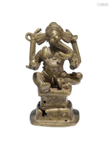 A small bronze figure of Ganesha, 18th century, shown seated on a square, tiered base, with curled