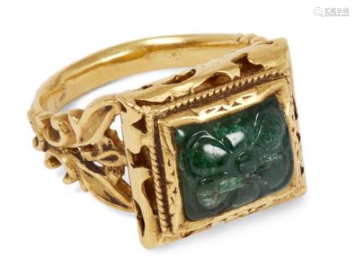 A carved emerald set gold ring, India, 20th century, the square bezel set with an emerald carved