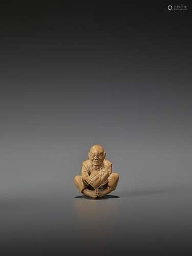 A WOOD NETSUKE OF A MAN WITH DARUMA TOY DOLL