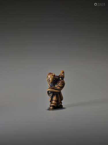 YOSHI:  WOOD NETSUKE OF A BOY WITH HORSE PUPPET