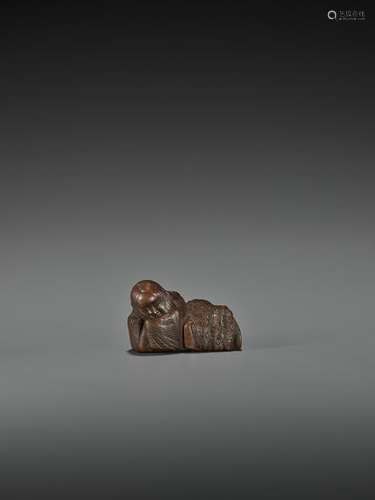 IKKAN: A WOOD NETSUKE OF A SLEEPING SHOJO