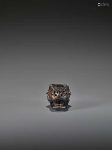 A KUROGAKI WOOD NETSUKE OF A SHISHI MASK