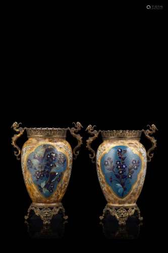 A pair of polychrome porcelain vases decorated with birds amongst flowering branches, with gilt