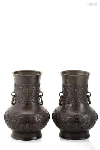 A pair of bronze vases with twin ring handles, decorated in relief with parallel bands of archaistic