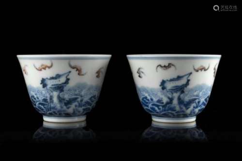 A pair of blue and white cups decorated with the foaming waves motif and flying auspicious bats