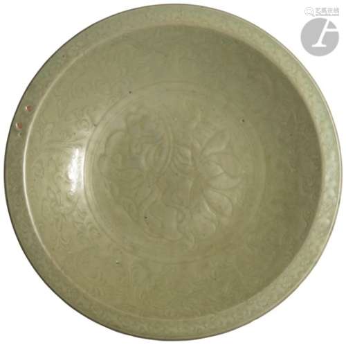 CHINE - Époque MING (1368 - 1644) Plat rond en grès émaillé vert céladon à décor incisé sous la