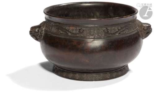 CHINE - XIXe siècle Brûle-parfum en bronze à patine brune orné de deux anses formant têtes de