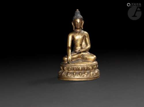 TIBET - XVIIe siècle Statuette du bouddha Sakyamuni en bronze doré, le visage laqué or, assis en