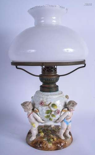 A NURSERY PORCELAIN OIL LAMP IN THE FORM OF THREE