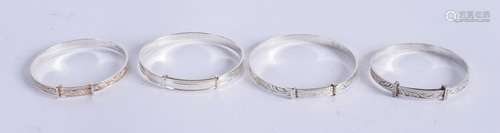 FOUR CHILDS SILVER BANGLES. 4.25 cm wide. (4)