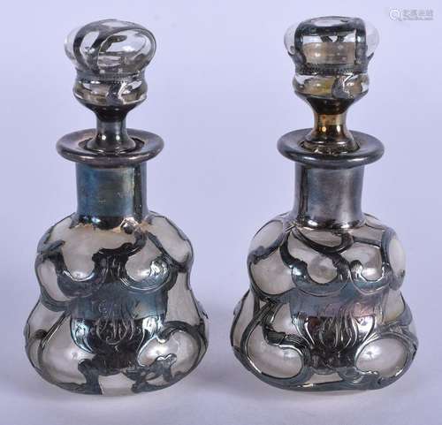 A PAIR OF SILVER OVERLAID ART NOUVEAU SCENT BOTTLES.