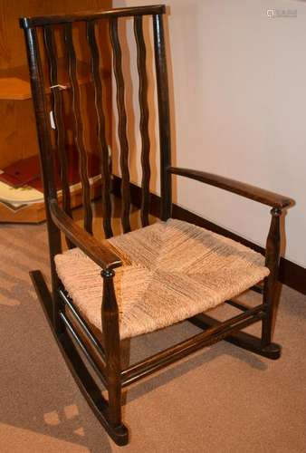 AN ANTIQUE OAK CHILDS ROCKING CHAIR, formed with