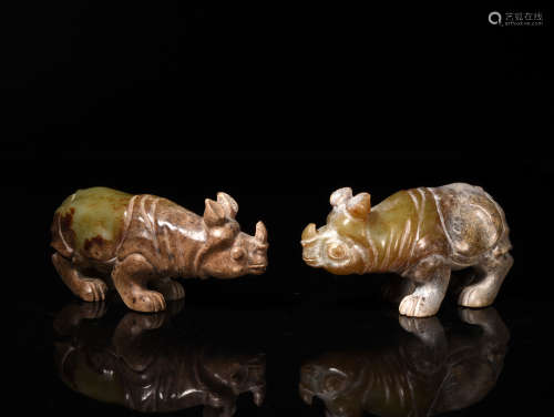 A PAIR OF CELADON AND RUSSET JADE RHINOS