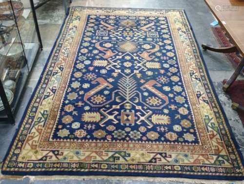 Blue ground rug, the central field with flowerhead and hooked motifs, stepped border, 239cm x 155cm