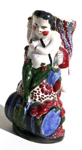 An early 19th century Prattware vase in the form of a man seated on a barrel holding a cornucopia,