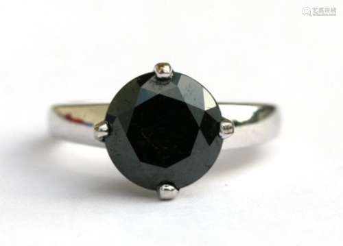 A 9ct white gold ring set with a large black diamond, approx UK size 'N'.