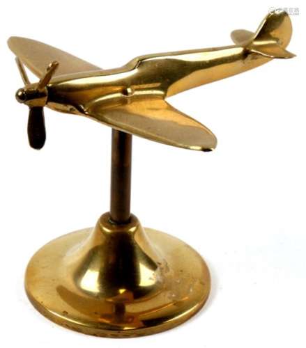 A brass model of the WW2 fighter the Supermarine Spitfire with spinning propeller mounted on its