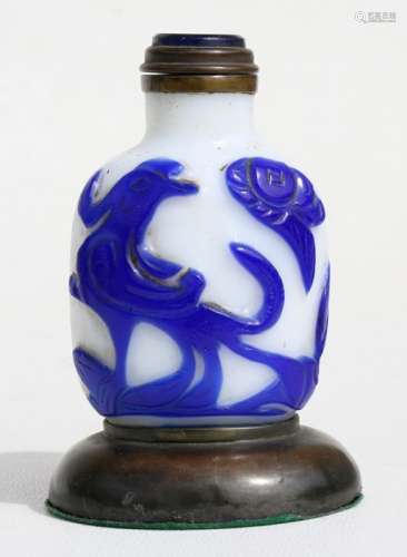 A Chinese cameo glass snuff bottle decorated with birds and flowers, mounted on a bronze stand, 9cms