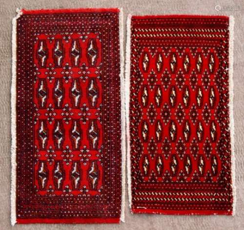 A pair of Persian Baluch woollen handmade rugs with geometric design on a red ground, each approx