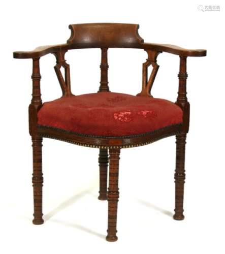 An Edwardian oak corner chair with upholstered seat, on ring turned legs.