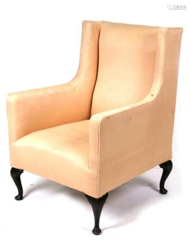 An Edwardian upholstered wing back armchair on cabriole legs.