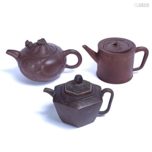 Three Yixing teapots Chinese, 19th/20th Century of varying forms, one with calligraphy engraved to