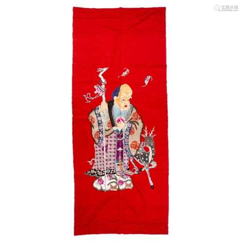 Red ground fabric panel Chinese depicting a standing Lohan with a staff in one hand and a deer by