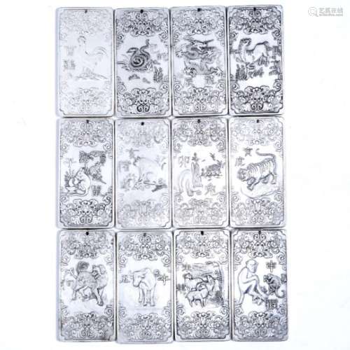 Set of twelve white metal ingots/pendants Chinese, early 20th Century each with five clawed dragon