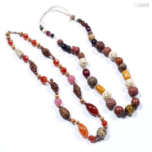 Two necklaces Chinese made up of carved nuts, ivory, amber and hardstone