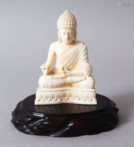 A 19TH CENTURY INDIAN CARVED IVORY BUDDHA, in a seated meditation position, on its hard wood
