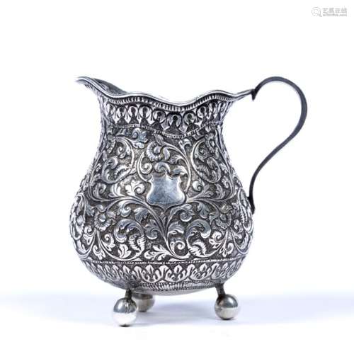 Small white metal cream jug Indian, late 19th Century foliate scroll designs 9cm high