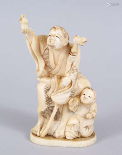 A JAPANESE MEIJI PERIOD CARVED IVORY OKIMONO OF MAN & BOY, the man stood holding his hand aloft