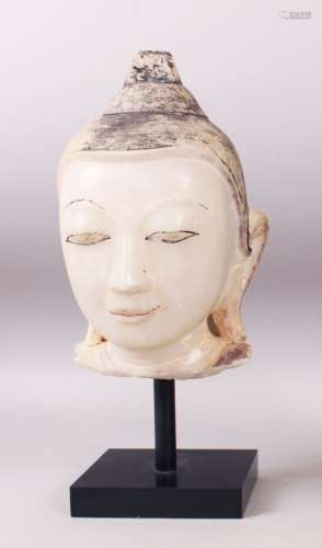 A 19TH CENTURY CARVED WHITE MARBLE BURMESE BUDDHA HEAD with painted headdress, on a pedestal base.