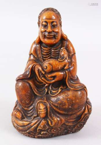 A GOOD CHINESE CARVED SOAPSTONE FIGURE OF LUOHAN HOLDING A CHILONG, seated on a stylized cloud base,