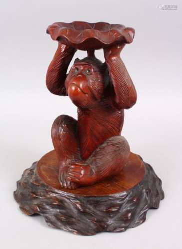 A JAPANESE MEIJI PERIOD CARVED HARDWOOD STAND IN THE FORM OF A MONKEY, the monkey realistically