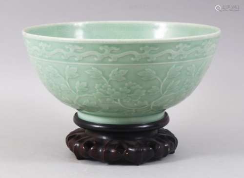 A GOOD CHINESE CELADON CARVED BOWL & HARDWOOD STAND, the bowl carved with formal scrolling lotus and