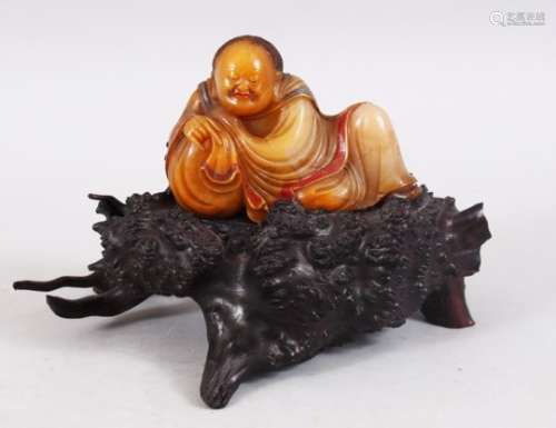 A GOOD QUALITY CHINESE CARVED SOAPSTONE FIGURE OF LUOHAN ON NATURALISTIC BASE, the luohan in a
