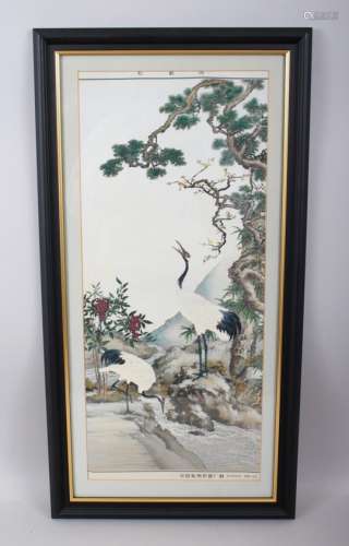 A CHINESE 20TH CENTURY FRAMED EMBROIDERED SILK / TEXTILE OF CRANES, the cranes stood amongst a river