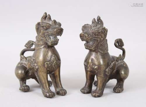 A PAIR OF 20TH CENTURY CHINESE BRONZE QUILIN / GUARDIAN DOGS, both in seated poses, 12cm high x 11cm