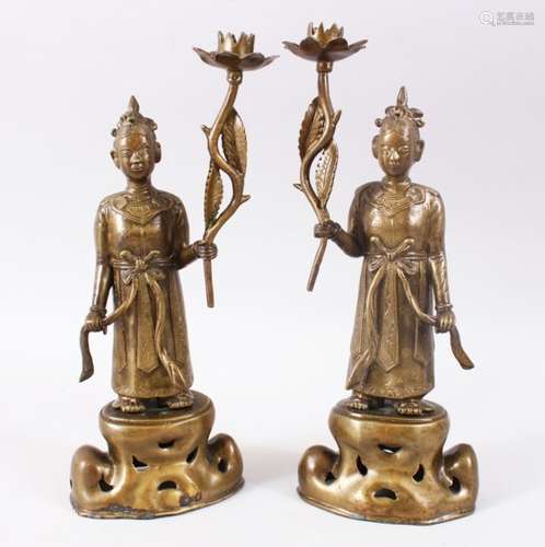 A GOOD PAIR OF 20TH CENTURY CHINESE BRONZE CANDLE STICKS, in the form of figures holding flowers,