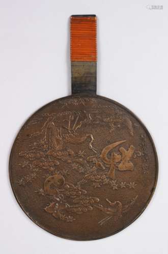 A GOOD JAPANESE MEIJI PERIOD BRONZE MIRROR, decorated with cranes flying amongst native flora,