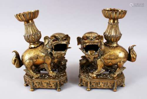 A PAIR OF 19TH / 20TH CENTURY CHINESE BRONZE CANDLESTICKS IN THE FORM OF LION DOGS, the pair of dogs