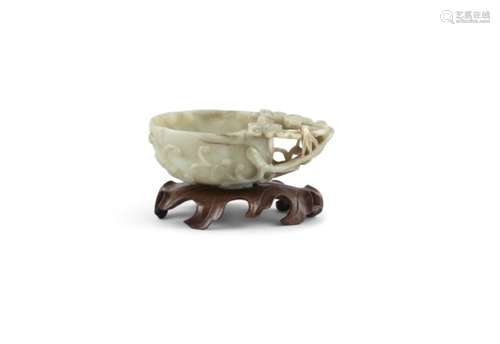 A CHINESE JADE 'MELON' LIBATION CUP, 18th century, of pale celadon tone with small brown inclusions,