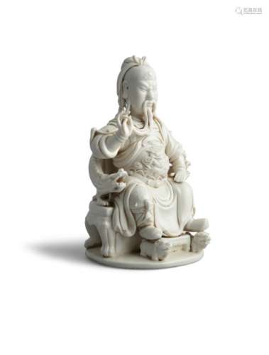 A CHINESE BLANC DE CHINE FIGURE OF KUANTI, Circa 1900, God of War, seated on a dragon throne, with