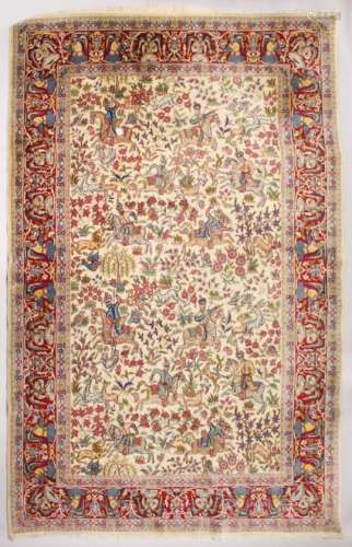 AN INDIAN CARPET, beige ground decorated all-over with a hunting scene, within a red ground border