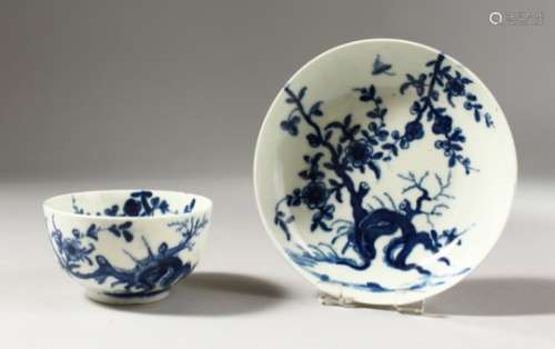 A WORCESTER BLUE AND WHITE TEA BOWL AND SAUCER, painted with a tree root and flowering prunus,