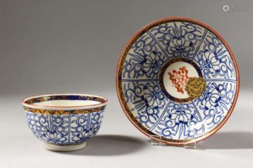A WORCESTER BLUE AND WHITE TEA BOWL AND SAUCER, with added red decoration, painted with a pattern