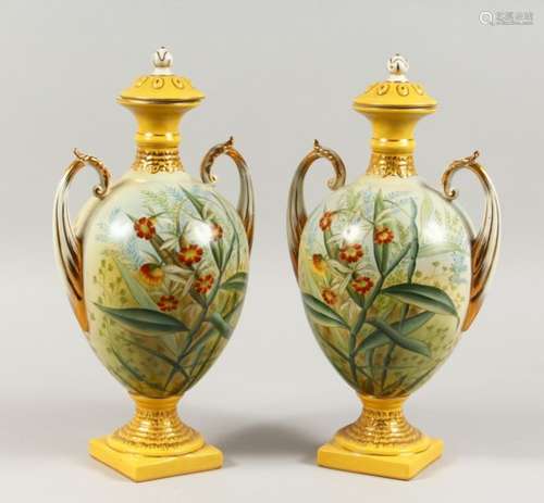 A PAIR OF SEVRES STYLE TWIN-HANDLED PEDESTAL VASES AND COVERS, decorated with flowers. 14ins high.